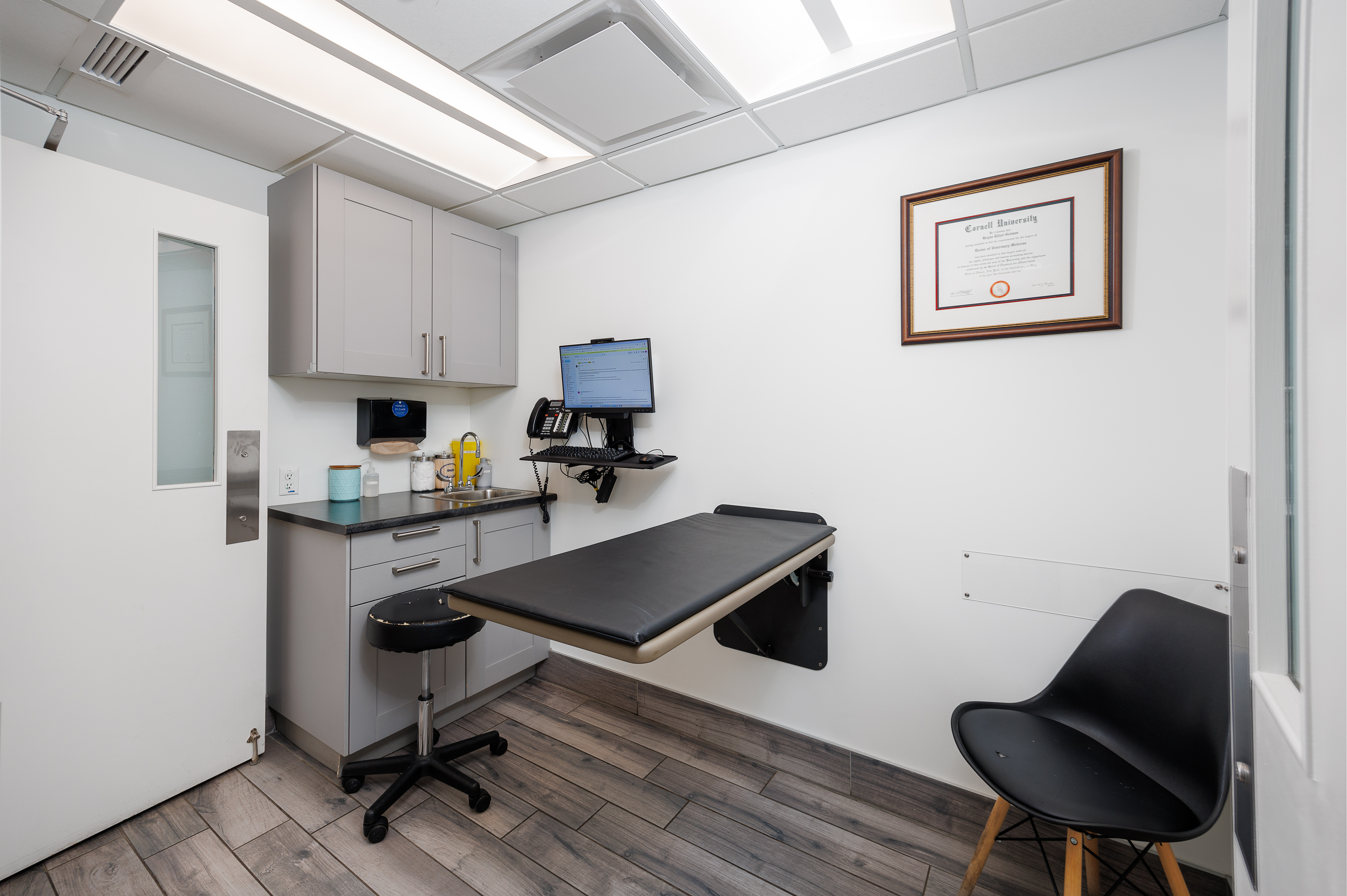 The image shows a well-equipped dental office with a modern chair, sink, and computer setup for patient consultations and treatments.